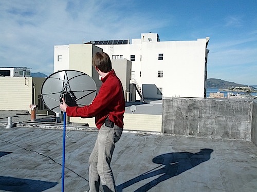 [Aiming the dish at a building]