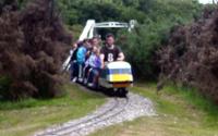 [Miniature railway crossing an old suspension bridge]